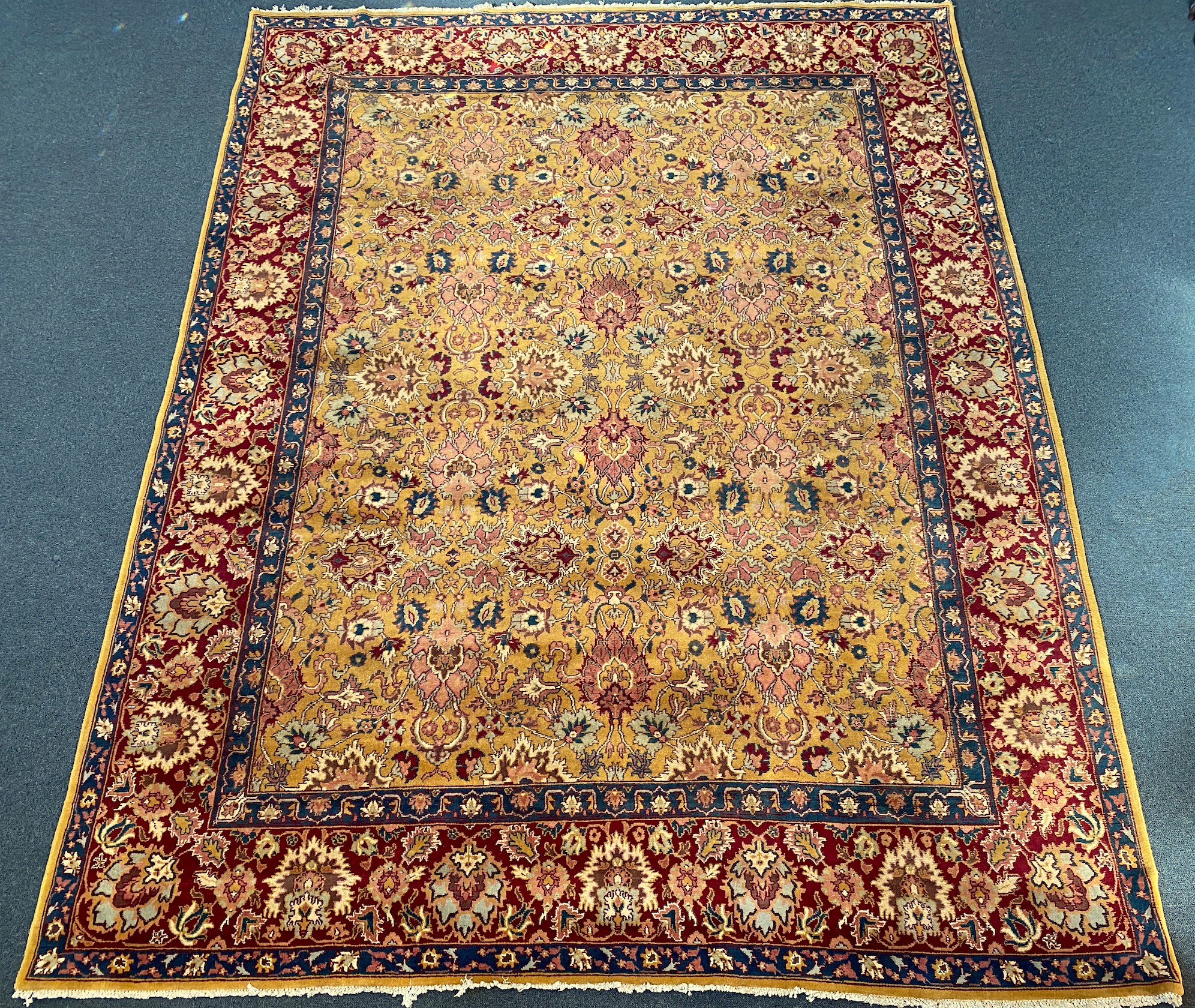 An Agra gold ground carpet with dense palmette field and wide conforming border 360 x 280 cms